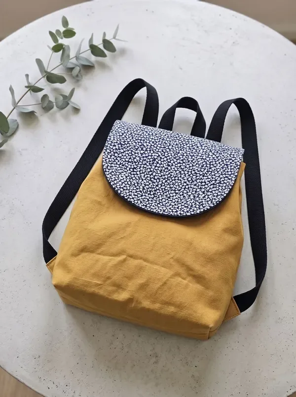 The FLAP Pack: mustard mini backpack with a navy print flap
